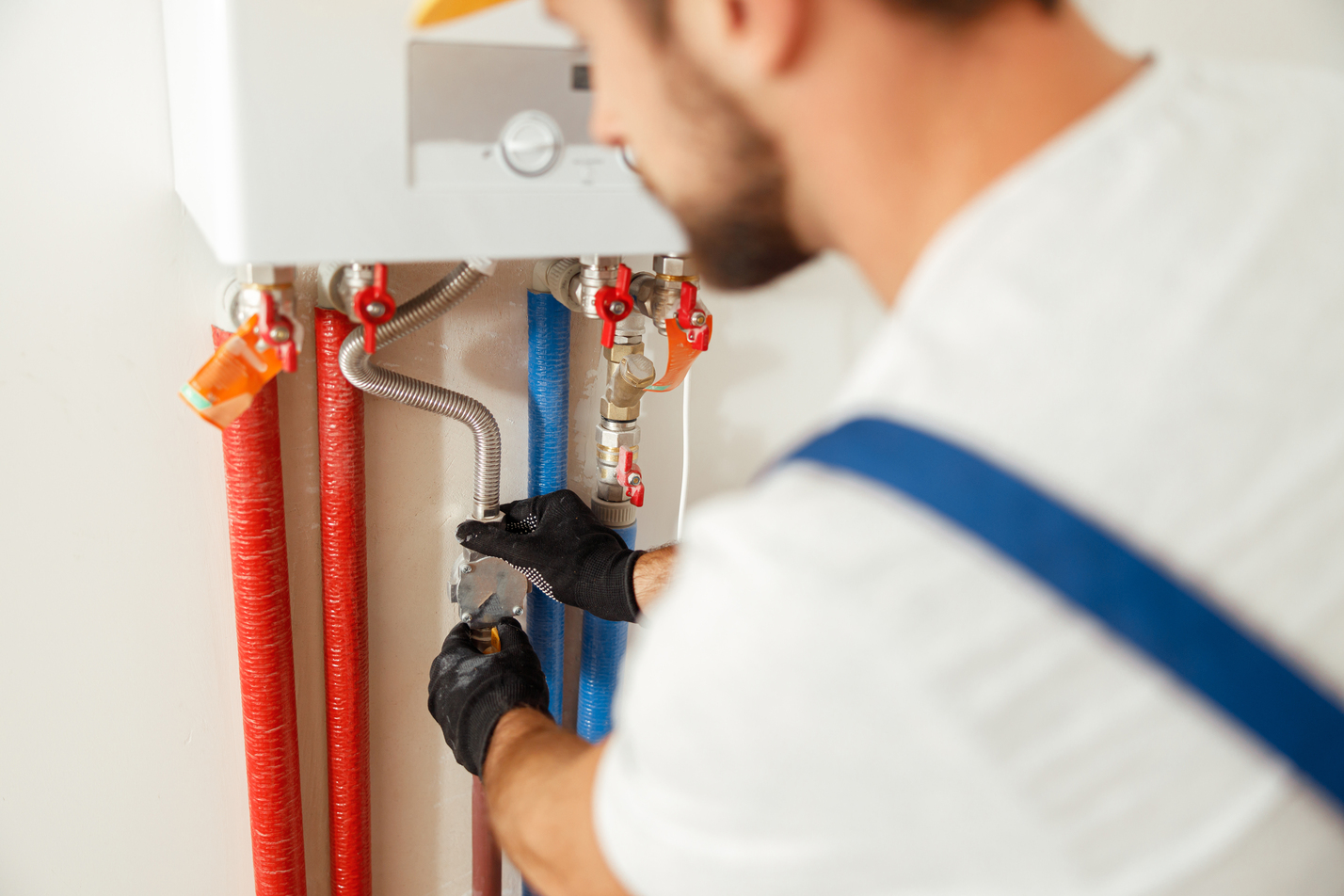 Closeup of plumber working with water pipes while installing heating system in apartment. Manual work, maintenance, repair service concept